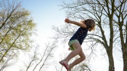 Pige hopper på trampolin udenfor om aftenen